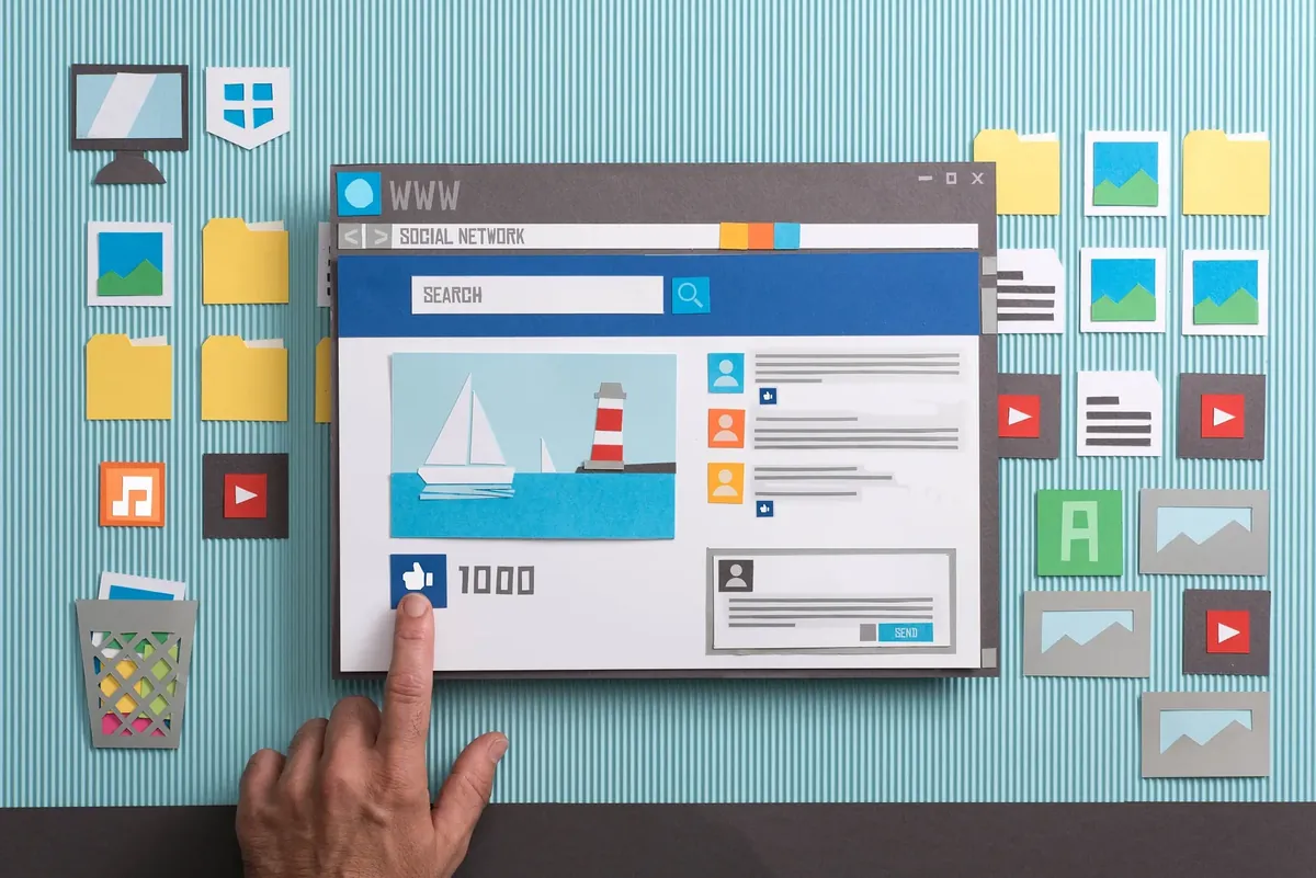 A finger pointing at the like button on a social network site.