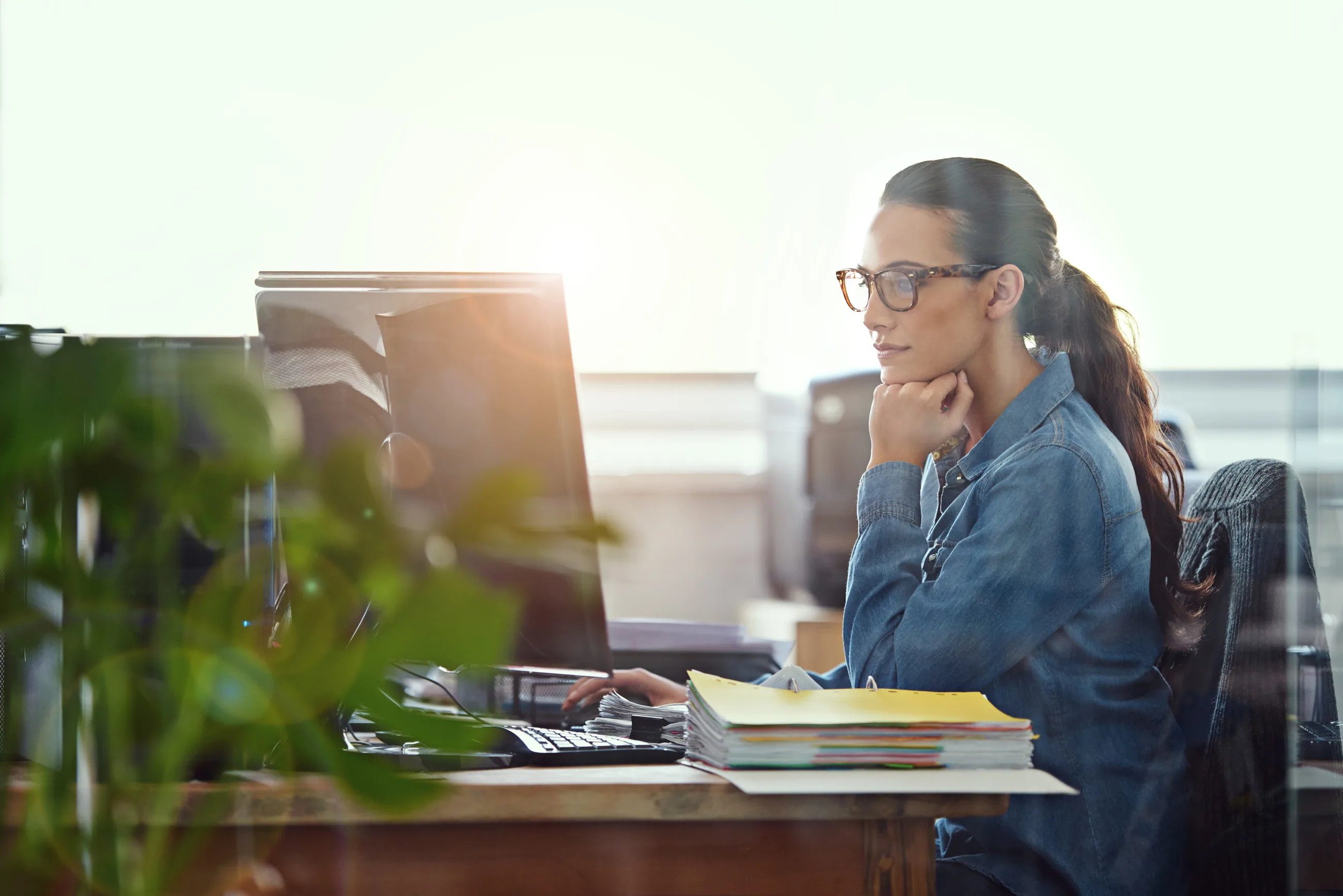 Somebody in the office at her desk, working through the files on her own