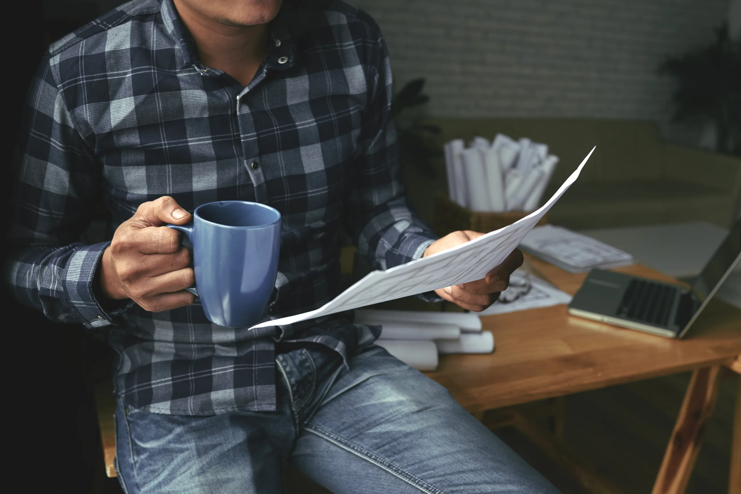A business owner reading a page of results with a coffee in his hand