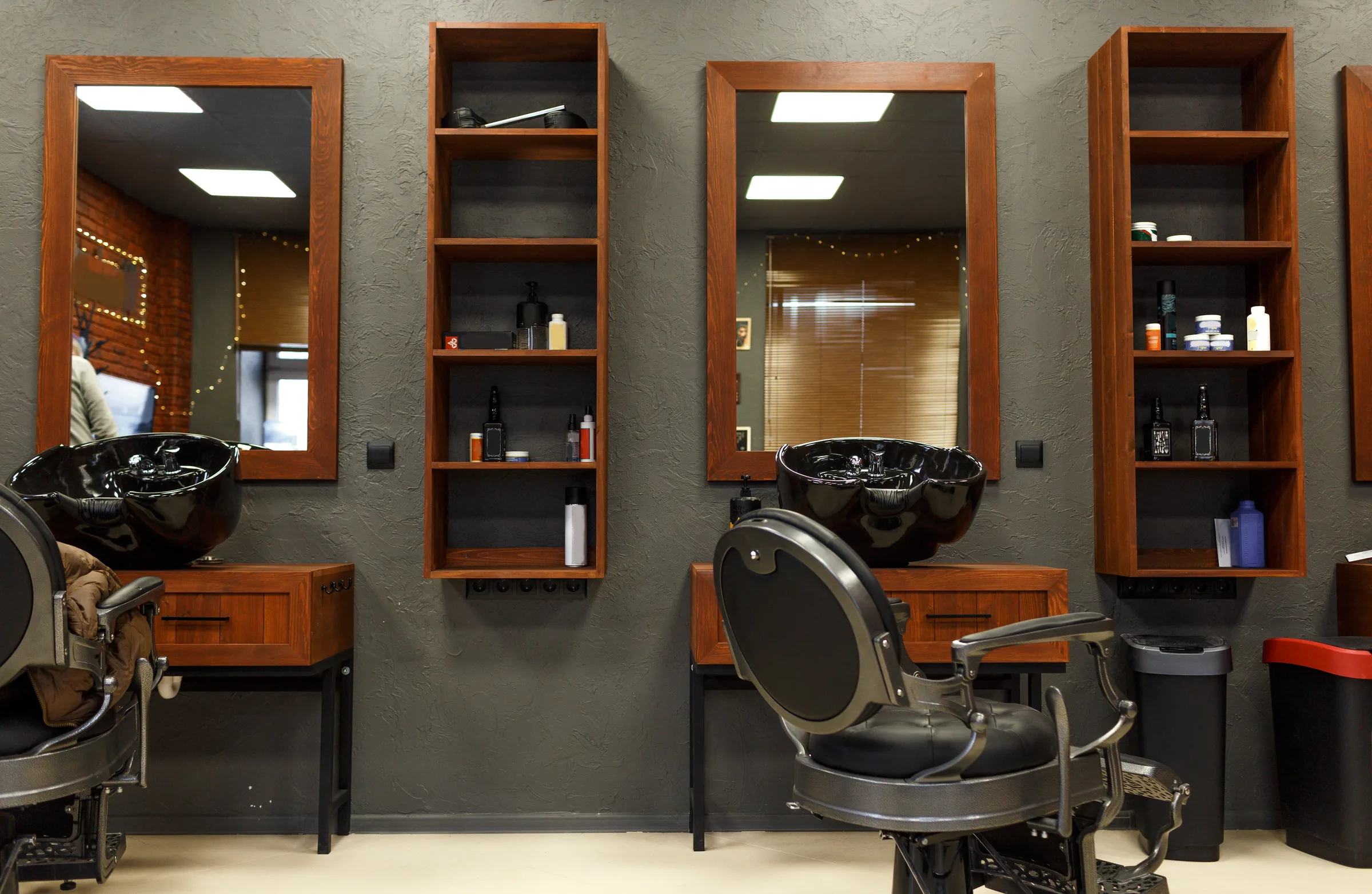 An empty barber's chair in front of the mirrors